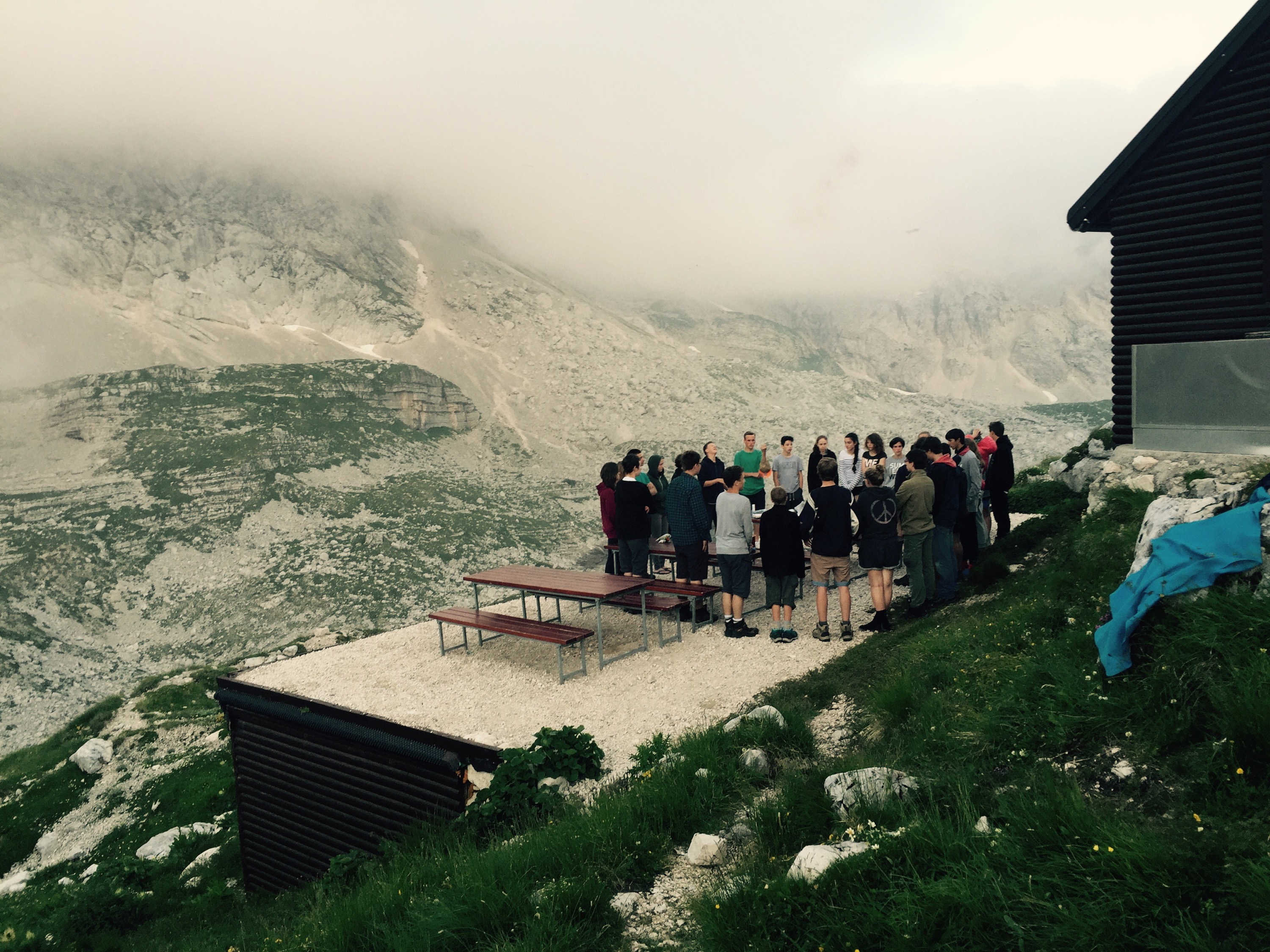 Young hiking group sing hymn, Zasavska koća, Triglavski National Park