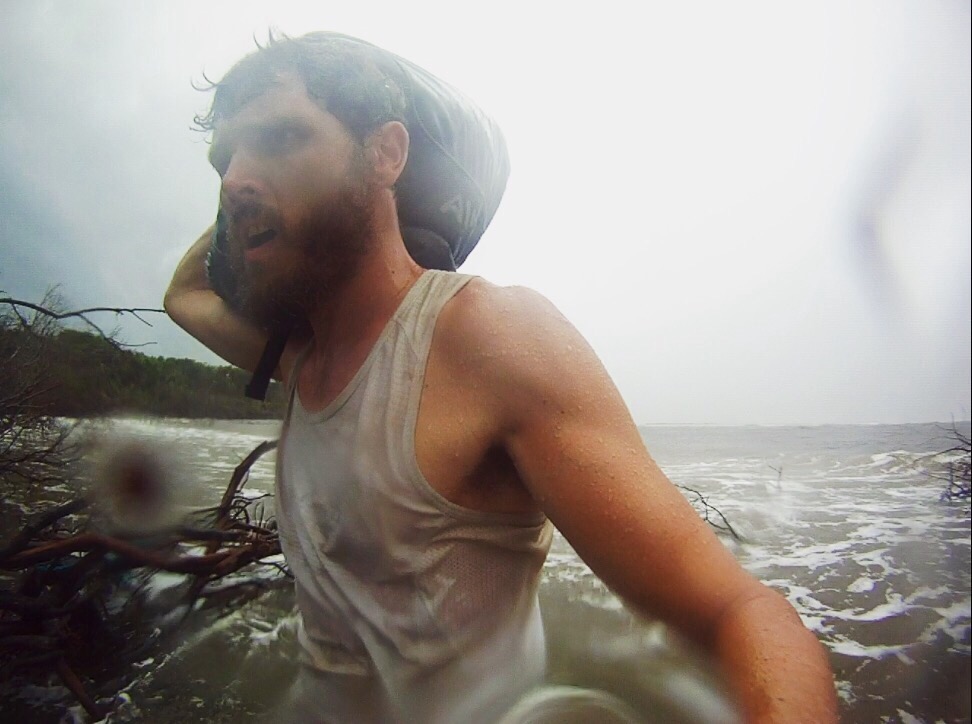 Paul Ferguson walking bag along Ararapira beach, Brazil